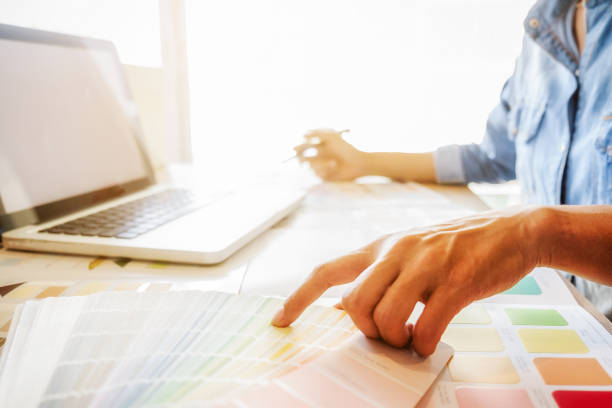 istock Graphic design and color swatches and pens on a desk. Architectural drawing with work tools and accessories. 654939390