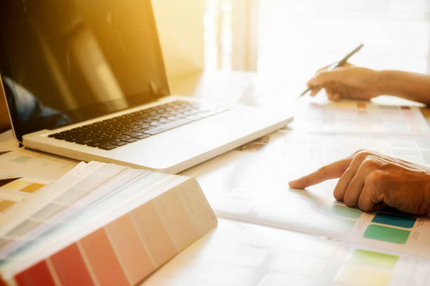 istock Graphic design and color swatches and pens on a desk. Architectural drawing with work tools and accessories. 654939396