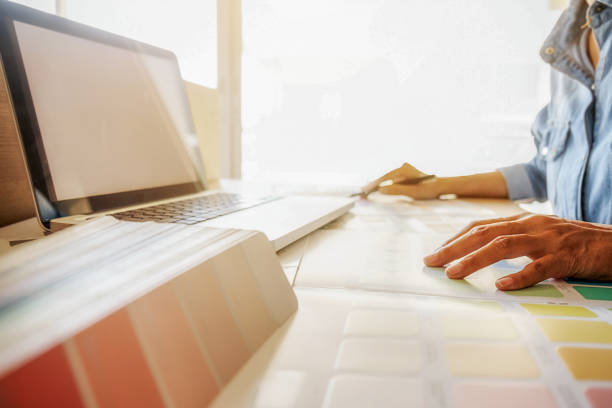 istock Graphic design and color swatches and pens on a desk. Architectural drawing with work tools and accessories. 654939402