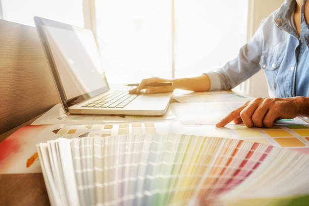 istock Graphic design and color swatches and pens on a desk. Architectural drawing with work tools and accessories. 654939410