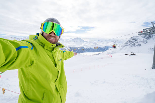 istock Young man taking selfie in ski slope, Switzerland 654939640
