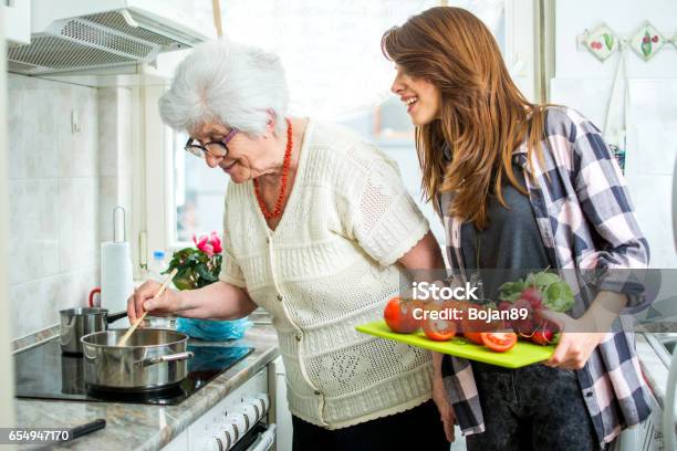 Grandmother And Her Granddaughter Cooking Together In Kitchen Stock Photo - Download Image Now