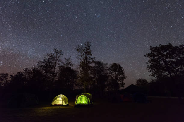 istock Camping tent glows under a night sky full of stars. 654956870