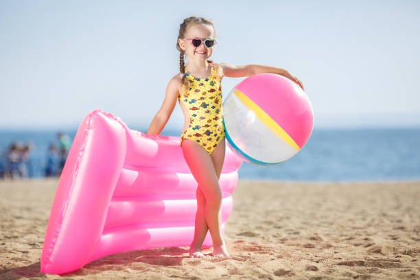 istock little girl playing on the sea shore. 654957616