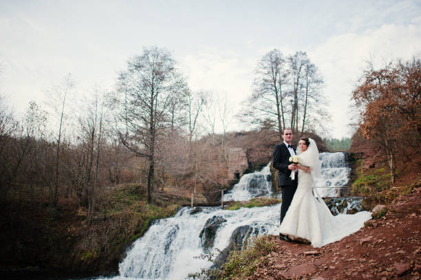 istock lovely newlyweds background waterfall at cold autumn day 654960808