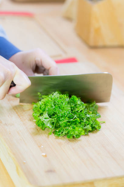 istock Chopped fresh parsley on wooden chopping board 654992568