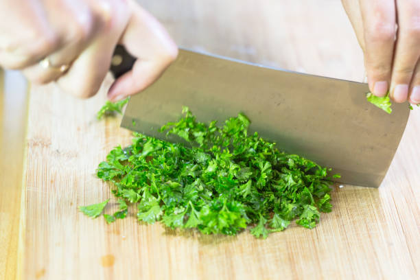 istock Chopped fresh parsley on wooden chopping board 654992680