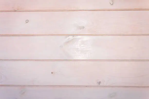 Wooden background. Pale-pink painted horizontal planks.  Texture of wood shows through paint .