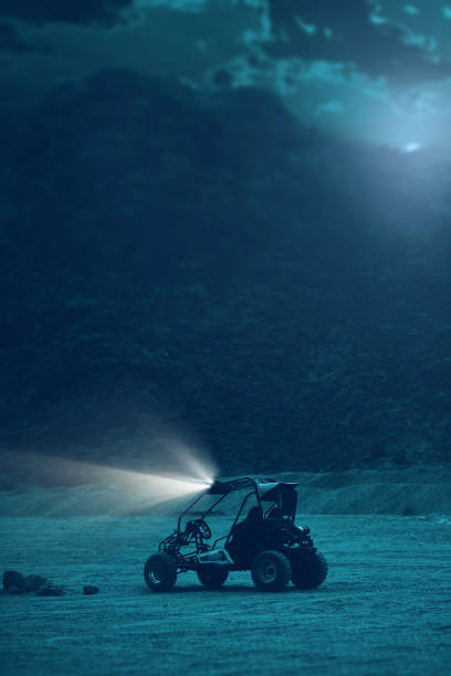 side view of Quad ATV lighting in the night time in desert.