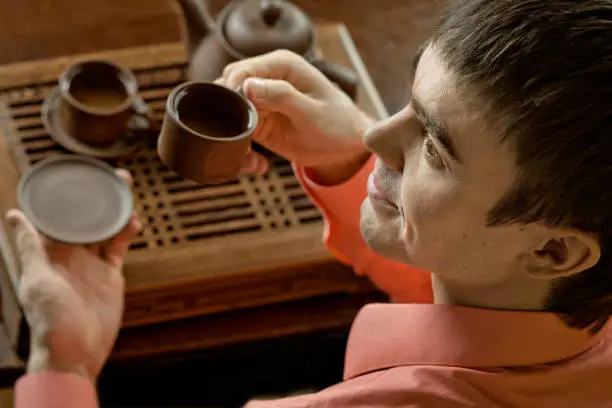 horizontal closeup portrait  the  beautiful man hold cup with green  tea