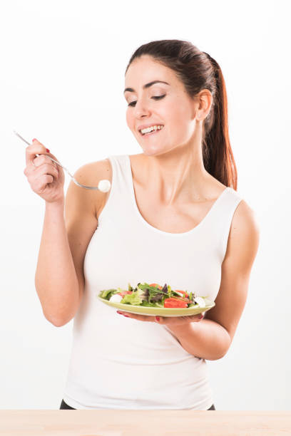 istock Young woman eating salad 655007588