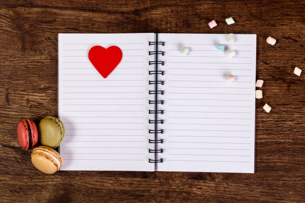 Woman diary with heart and Macaroons with marshmallows. Opened blank notebook. Valentines day concept with empty notepad.