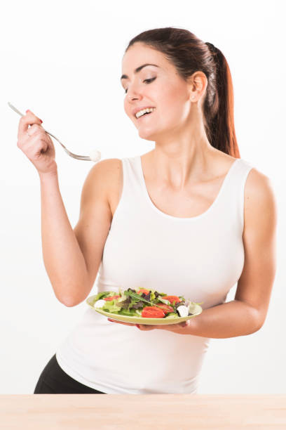 istock Young woman eating salad 655007934