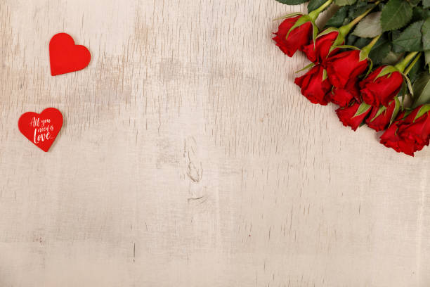 istock Red roses with hearts on wooden background. 655008426