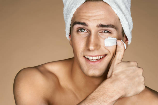 istock Handsome young man applying cream to his face. 655012180