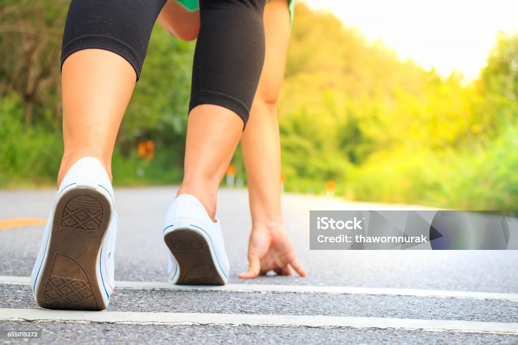 Chica empezando a correr en la carretera - Foto de stock de Actividad libre de derechos