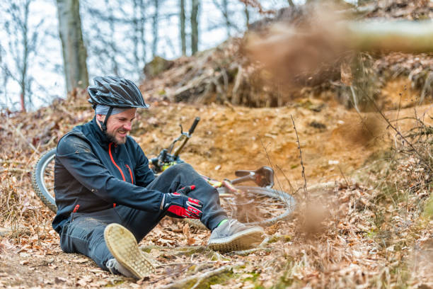 young man fell off mountain bike - wood dirt road footpath exercising imagens e fotografias de stock