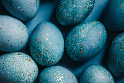 Modern hand dyed blue easter eggs with golden spots
