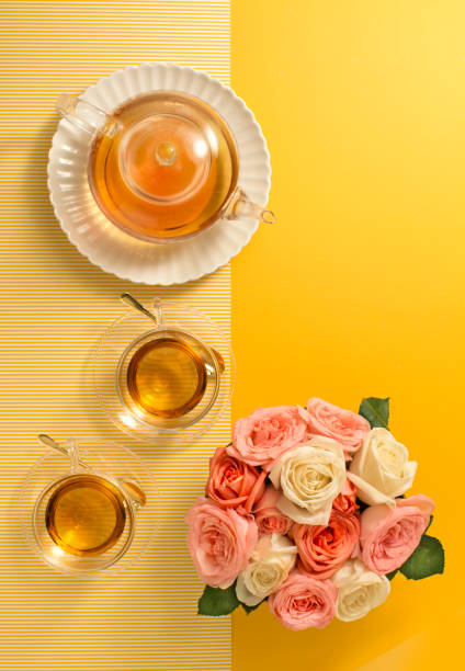 istock English tea set and rose bouquet on yellow background. 655038432