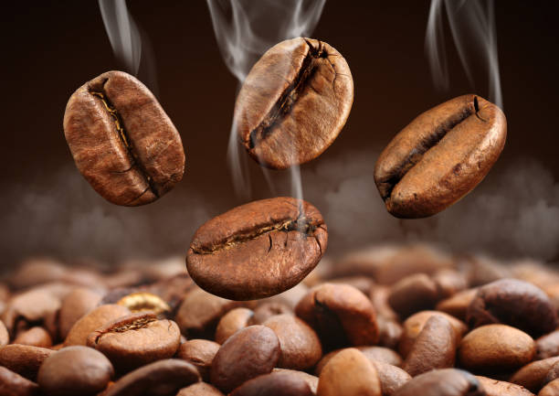 istock Macro falling coffee bean with steam on brown background 655044804