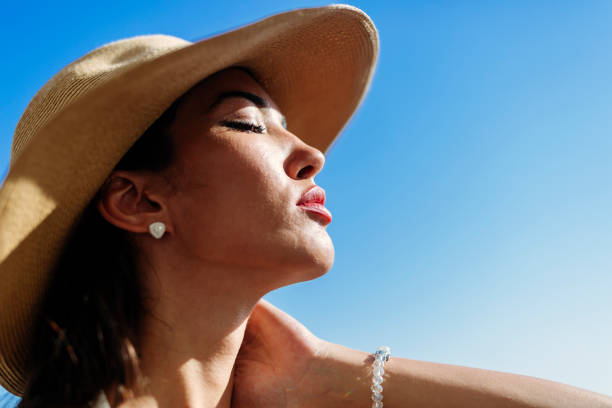 istock Glamorous woman looking towards the sun while wearing a hat 655050486