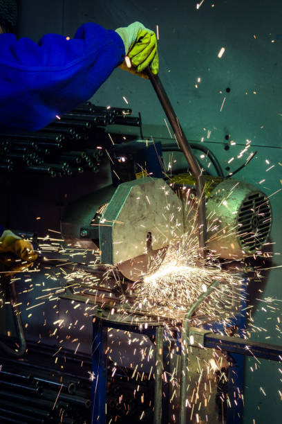 istock Worker cutting steel pipe with a flash of sparks 655053450
