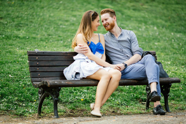 istock Romantic couple in park sitting on bench 655054010