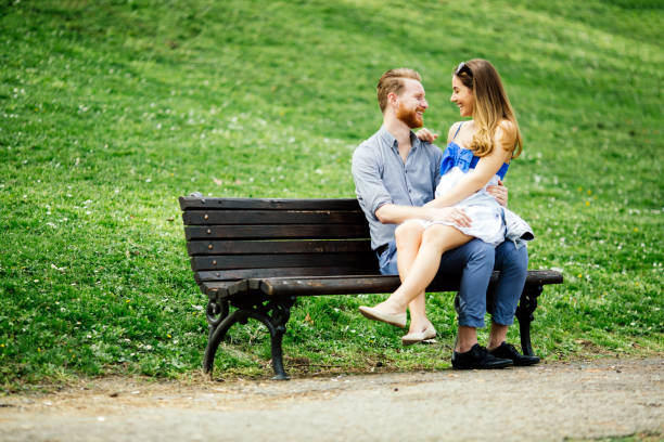 istock Romantic couple in park sitting on bench 655054106
