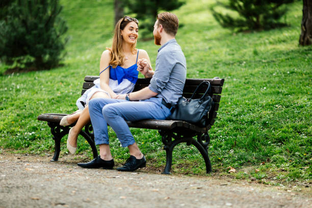 istock Romantic couple in park sitting on bench 655054140