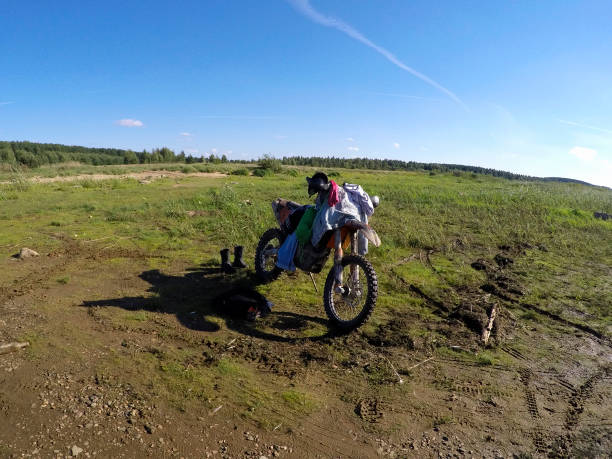 motorcycle with rider standing in field
