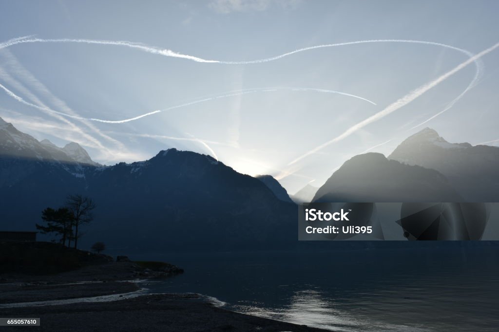 Jetstreams in the sky above the lake at sundown nr.2 Commercial airline jet streams Airplane Stock Photo