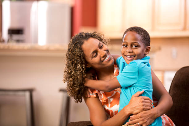 istock African descent single mother hugs young son at home.. 655060852