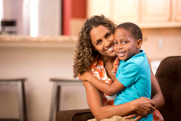 istock African descent single mother hugs young son at home.. 655065300