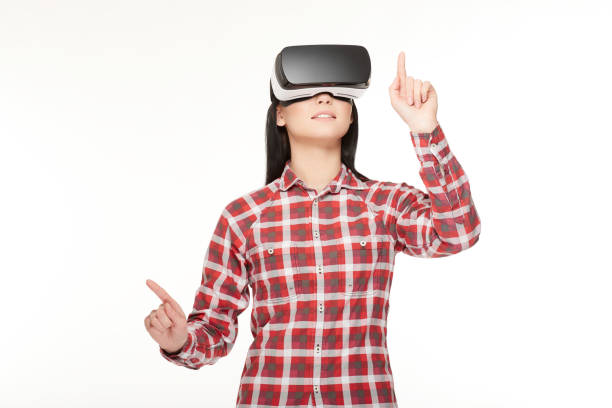 istock Girl in VR headset making choose and pointing by fingers 655065992
