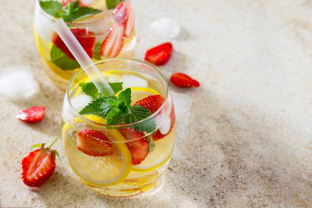istock Traditional summer Mojito drink with lemon and strawberry with copy space on brown stone background. The concept of eating vegetarians and fresh vitamins. 655084618