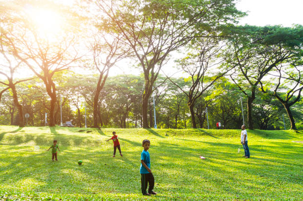 bambini che giocano al parco pubblico al mattino con una splendida luce solare. - selangor state foto e immagini stock