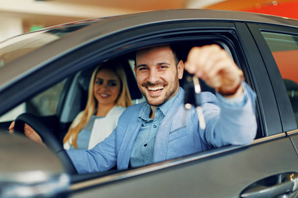 Young couple holding the keys of a new car stock photo
