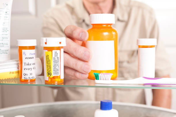 senior hombre adulto obtiene medicamentos de la caja. - medicine cabinet cabinet medicine bathroom fotografías e imágenes de stock