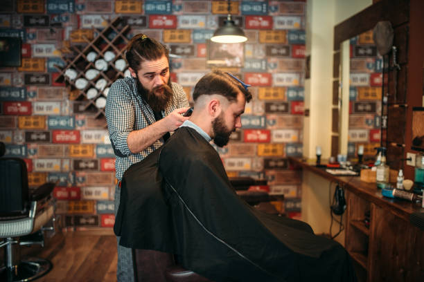 istock Barber makes hairstyle of client man by clipper 655104628