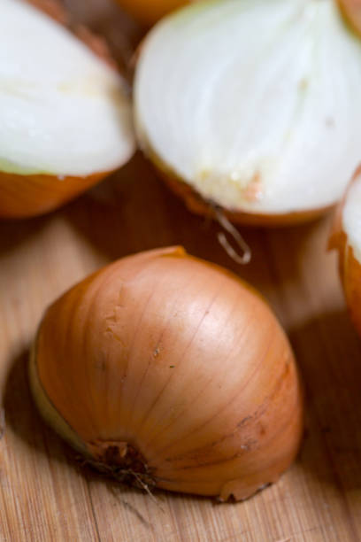 istock Brown onion cut in half on wooden chopping board 655108476