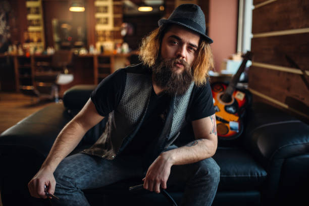 istock Bearded barber sitting on black leather couch 655108798