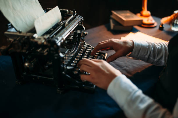 literature author in glasses typing on typewriter - typewriter writing retro revival old fashioned imagens e fotografias de stock