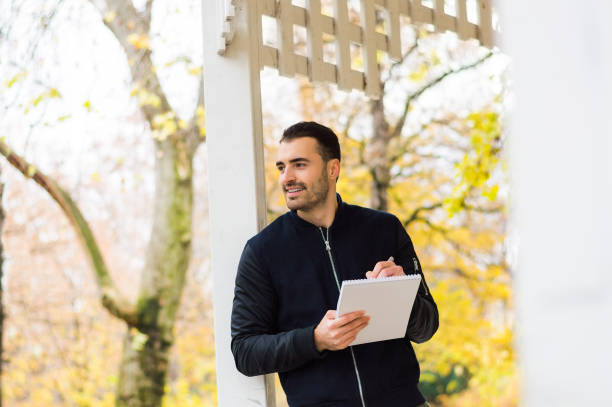 istock Handsome left handed man writing at the park 655119944