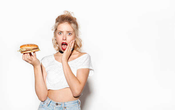 istock Surprised young woman holding a burger 655127262