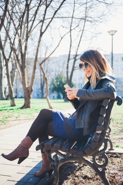 istock Young woman using smartphone in the park 655127642