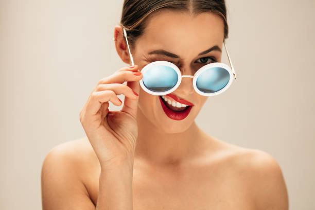 mulher bonita, piscando com óculos - sunglasses women smiling portrait - fotografias e filmes do acervo