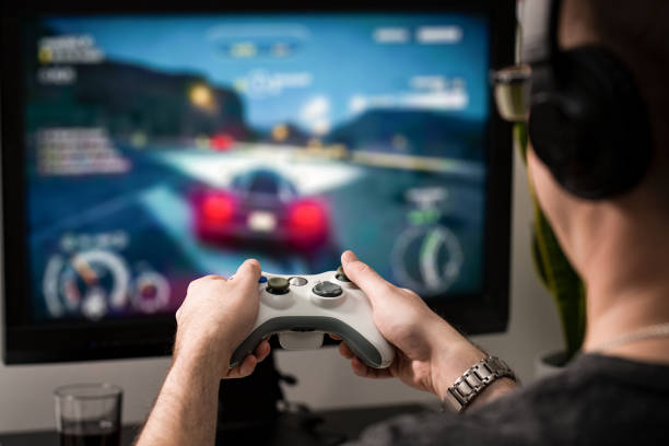 Gaming game play video on tv or monitor. Gamer concept. gaming game play tv fun gamer gamepad guy controller video console playing player holding hobby playful enjoyment view concept - stock image game controller photos stock pictures, royalty-free photos & images