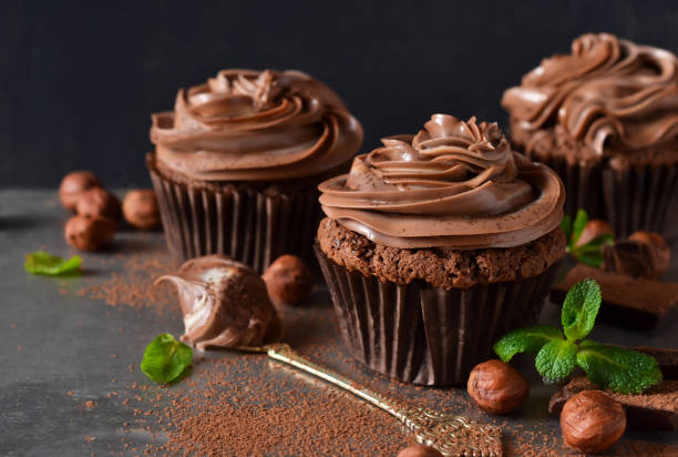 Chocolate cupcakes with peanut paste the old grunge background Chocolate cupcakes with peanut paste the old grunge background cupcake stock pictures, royalty-free photos & images