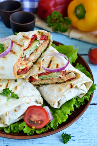 istock shawarma Lavash with chicken, tomatoes, lettuce and peppers on a blue background 655156192
