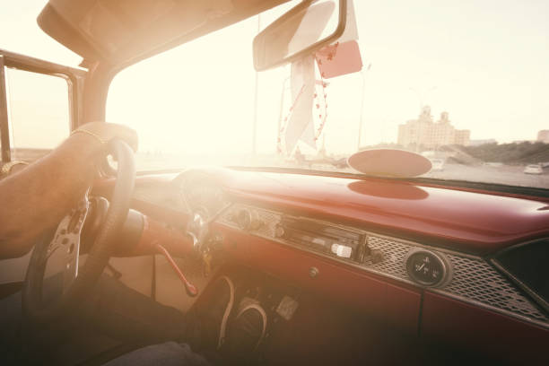 man driving convertible along Malecon, Havana, Cuba